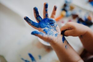 child playing with blue paint