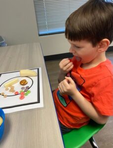 young boy receiving feeding therapy by professionals