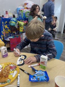 Child coloring in a mask at a birthday party.